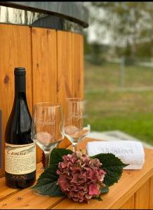 a table with two wine glasses and a bottle of wine at Dom z balią na Kaszubach-Widokova in Borucino