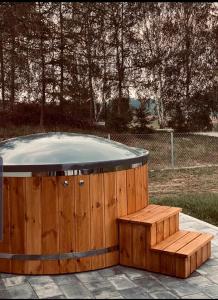 een houten hot tub met een bank ernaast bij Dom z balią na Kaszubach-Widokova in Borucino