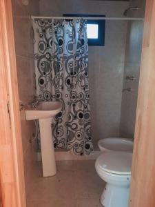 uma casa de banho com um WC e uma cortina de chuveiro em Cabañas El Encuentro Lobos em Salvador María