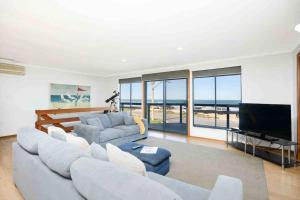 a living room with a couch and a flat screen tv at The Rise on Surfer- BEACHFRONT Pet Friendly WIFI in Middleton