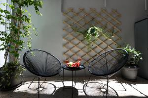 dwa krzesła i stół na dziedzińcu z roślinami w obiekcie apt Seventeen_2-bedroom flat_Athens citycentre w Atenach