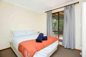 a bedroom with a bed with an orange blanket and a window at The Rise on Surfer- BEACHFRONT Pet Friendly WIFI in Middleton