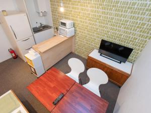 郡上市にあるunattended check-in accommodation in Gujo Hachimanの小さなお部屋で、椅子、テーブル、テレビが備わります。