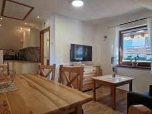 a living room with a wooden table and a kitchen at Kukurooms in Koniaków