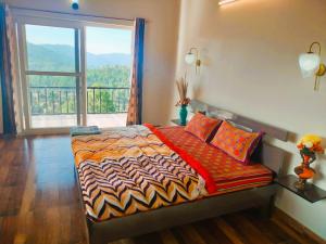 a bedroom with a bed and a large window at ValleyView Homestay in Mukteswar