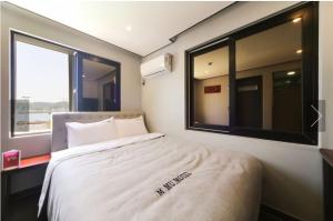a bedroom with a bed with a large window at Tongyeong Mu in Tongyeong