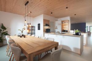 a dining room and kitchen with a wooden table and chairs at Chalet 48 in Mayen