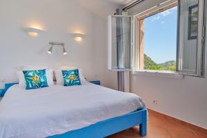 a bedroom with a bed and a window at Résidence Belvedere de Palombaggia in Porto-Vecchio