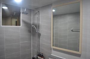 a shower with a glass door in a bathroom at Tongyeong Mu in Tongyeong