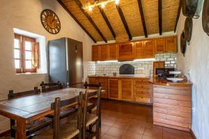 eine Küche mit einem Holztisch und einem Kühlschrank in der Unterkunft Casa Rural El Majano in Moya