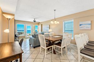 a dining room and living room with a table and chairs at Boardwalk Building Sunset Corner Condo in Gulf Shores