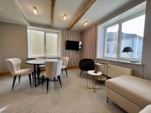 a room with a table and chairs and a couch at Apartments in Dobele city center - Pilsētas Māja in Dobele