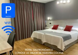um quarto de hotel com uma cama com almofadas vermelhas em Hotel Mozárbez Salamanca em Mozárbez