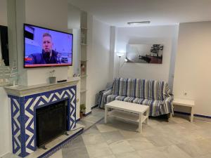 sala de estar con chimenea y TV de pantalla plana en Apartamento Medina Puerto Sherry, en El Puerto de Santa María