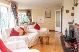 a living room with two white couches and a fireplace at Nevins Newfield Inn Ltd in Mulranny