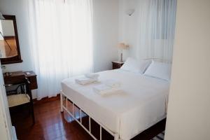 1 dormitorio con 1 cama blanca y 2 toallas en Beautiful Traditional Stone House in the private Sea Front Olive Grove of Elaionas Nikou Luxury Villas, en Alyfantá