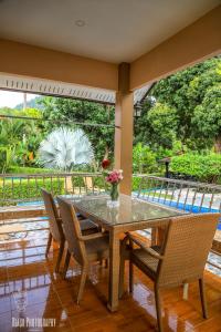 a dining room table and chairs with a view of a garden at Filou Villas in Ko Chang