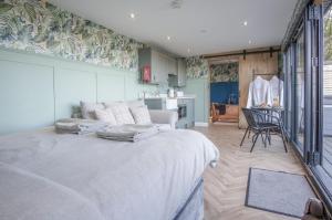 a bedroom with a large bed and a kitchen at The Caswell Bay Hide Out - 1 Bed Cabin - Landimore in Gowerton