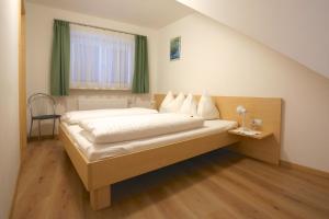 a bedroom with a bed and a window with green curtains at Residence die Färbe in Vipiteno