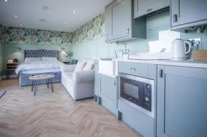 a kitchen and living room with a bed in a room at Brandy Cove - 1 Bed Cabin - Landimore in Gowerton