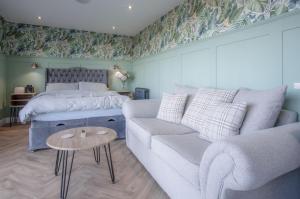 a bedroom with a bed and a couch and a bed and a couch and table at The Rhossili Bay Secret - 1 Bed Cabin - Landimore in Gowerton