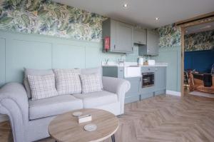 a living room with a couch and a table at The Rhossili Bay Secret - 1 Bed Cabin - Landimore in Gowerton