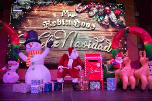 un grupo de muñecos de nieve sentados frente a un cartel en Magic Robin Hood, en Albir