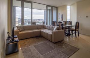 a living room with a couch and a table with chairs at The Quays at Point Waterfront Durban in Durban