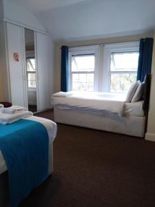 a hotel room with two beds and two windows at The Hillmorton Manor Hotel in Rugby