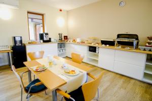 a kitchen with a table and chairs in a room at Hotel Adalbert Szent György Ház in Esztergom