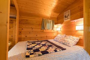 a bedroom with a bed in a log cabin at Roulotte de la Villa Font Vive - Tout équipée, tout confort, situation idéale Sud Ardèche in Grospierres