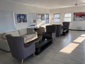 a living room with a couch and a table and chairs at Lovely, Modern, Contemporary 1 Bedroom Apartment. in Sandton