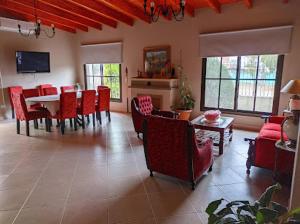 een woonkamer met rode stoelen en een eettafel bij Las Tres Marías in Salta