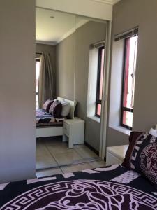 a bedroom with a mirror and a bed in a room at Lovely, Modern, Contemporary 1 Bedroom Apartment. in Sandton