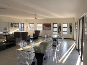 a living room with a glass table and chairs at Lovely, Modern, Contemporary 1 Bedroom Apartment. in Sandton