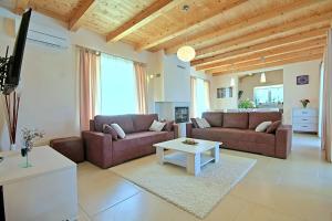 ein Wohnzimmer mit zwei Sofas und einem Tisch in der Unterkunft Villa Patricia in Sošići