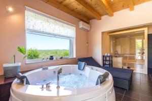 eine große Badewanne in einem Zimmer mit einem großen Fenster in der Unterkunft Villa Patricia in Sošići