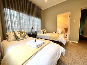 a hotel room with two beds and a mirror at Le Rendezvous in Dullstroom