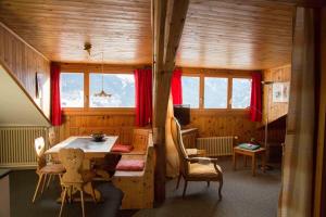 um quarto com uma mesa e cadeiras numa casa em Vichava 8, Süd em Ftan
