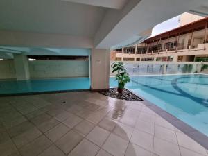 a swimming pool in a building with a potted plant at 4 pax Tagaytay Prime Staycation WIFI NETFLIX and light cooking FREE VIEWDECK in Tagaytay