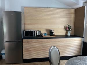 una cucina con bancone, forno a microonde e frigorifero di Hotel Royal Suite Santander a Santander