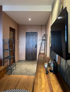 a living room with a television and a door at Hotel Kalang Ulu in Berastagi