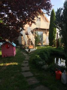 una casa con una casa de perros en el patio en ZSUTI BORHÁZ, MAGÁNSZÁLLÁSHELY, 