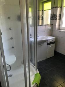 a bathroom with a shower and a sink at Apartamenty Rodzinne Krokowa in Krokowa