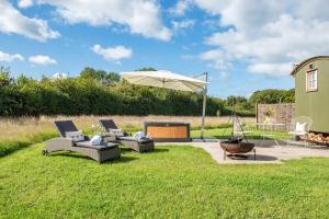 a patio with two couches and an umbrella at Black Mountain bespoke breaks in Brecon