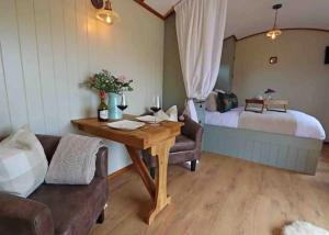 uma sala de estar com uma mesa e uma cama em Black Mountain bespoke breaks em Brecon