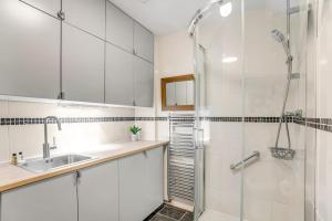 a white bathroom with a shower and a sink at Beautiful 2 bed apartment in the heart of the city in Norwich
