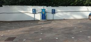 a white wall with a blue door in a parking lot at Greif Hotel Maria Theresia in Trieste