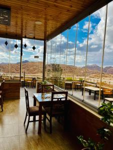 a restaurant with a table and chairs and windows at Esperanza Petra in Wadi Musa