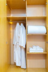 a closet with white robes and towels at Moon Hotel Cau Giay in Hanoi